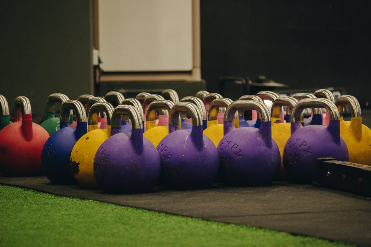Vibrant kettlebells neatly arranged on the gym floor, ready for workout sessions.
